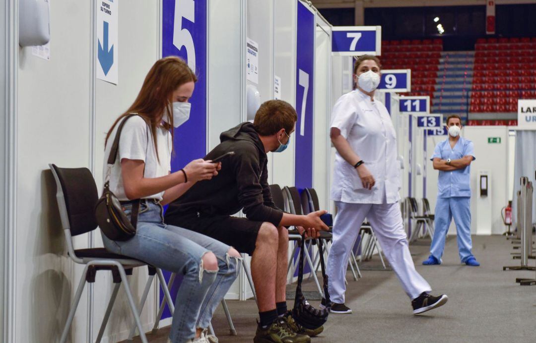 Dos jóvenes esperan en un punto de vacunación contra el coronavirus.