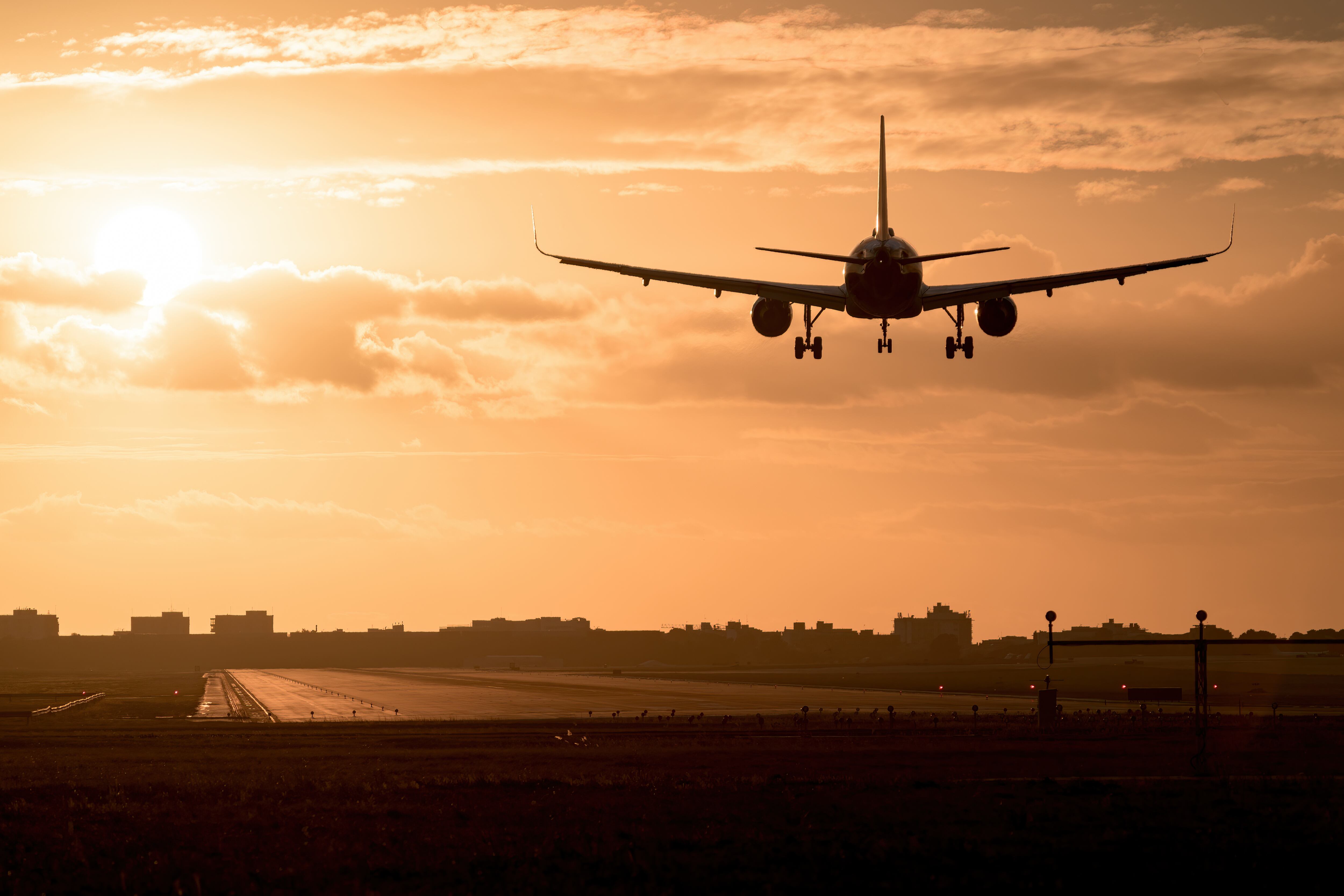 Un avión despegando al atardecer