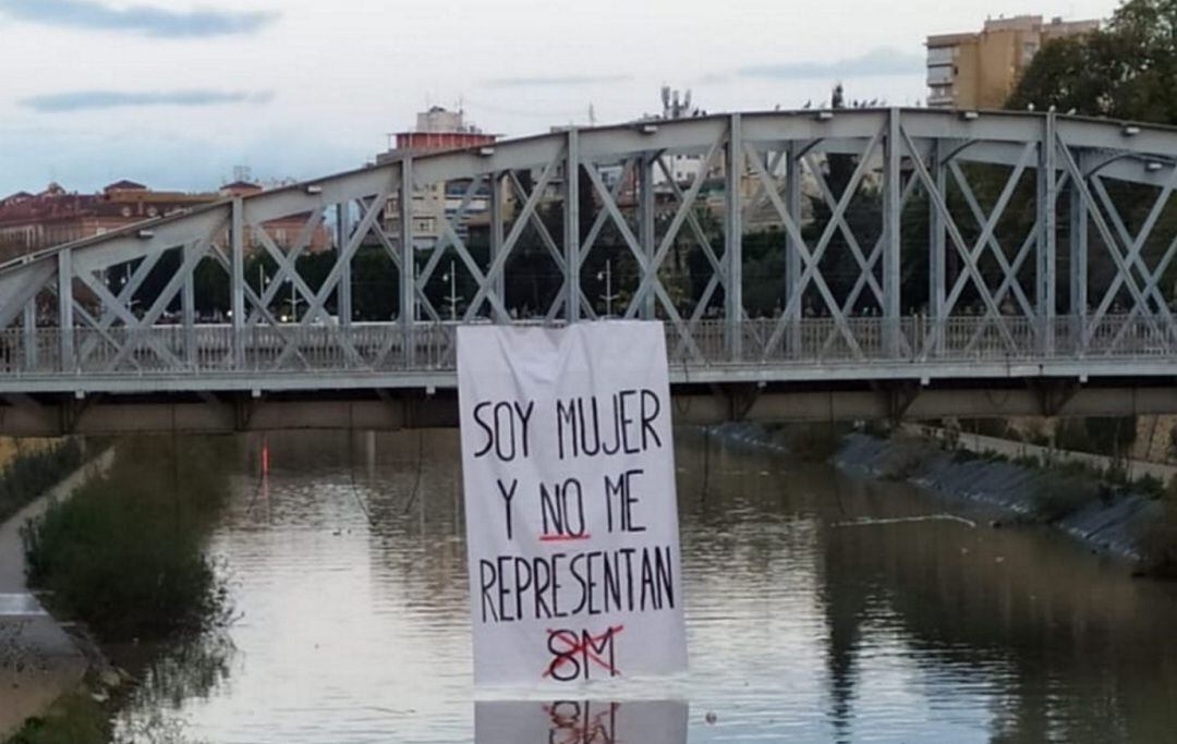 Fotografía que ha circulado en redes sociales, en realidad han sido tres hombres los que han colgado el cartel, según el diario La Opinión de Murcia