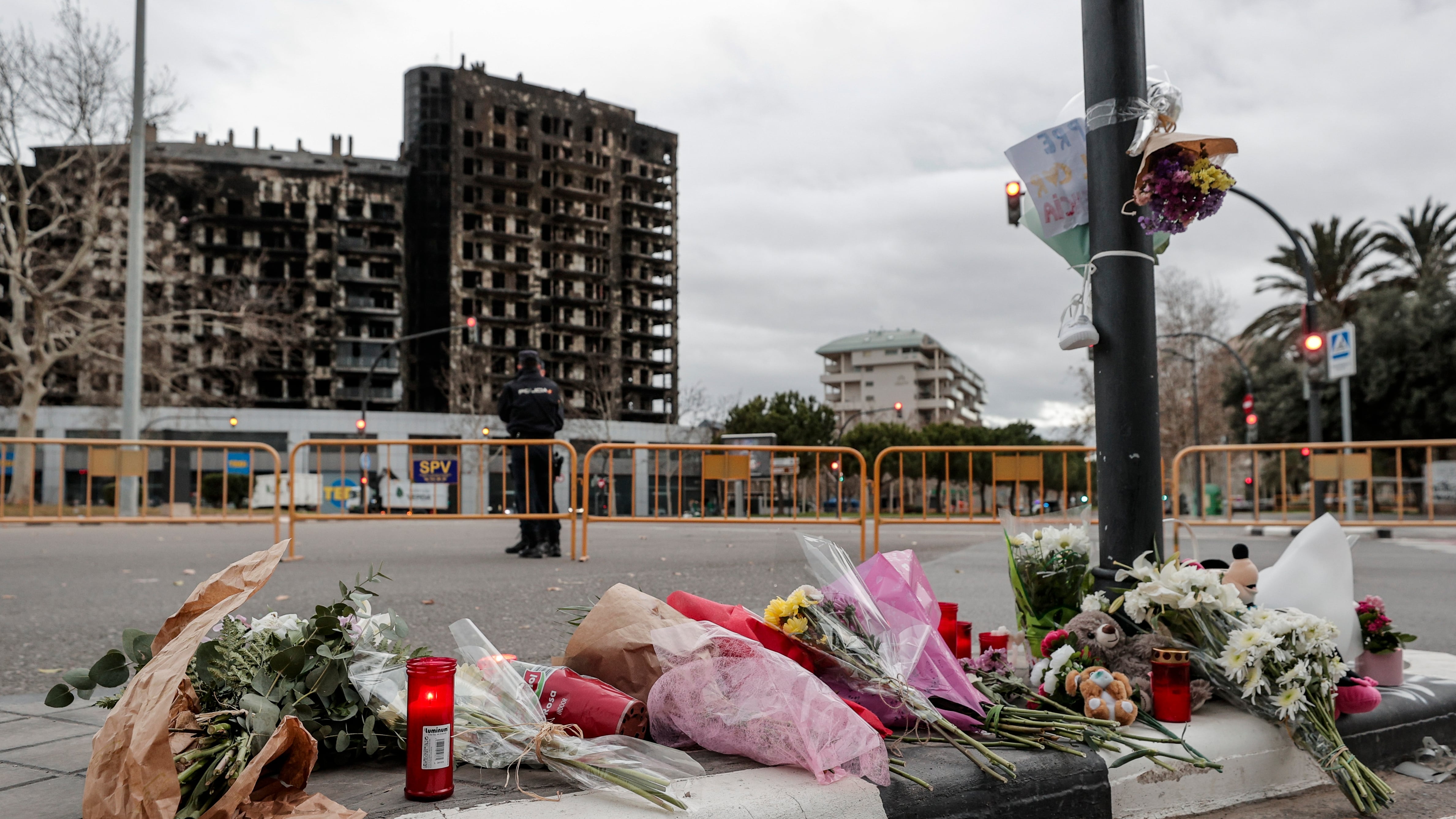 Tercera jornada de luto en València por las diez víctimas mortales del incendio de un edificio del barrio de Campanar. En la imagen flores, velas y algún peluche depositados ante el edificio incendiado. EFE/Manuel Bruque