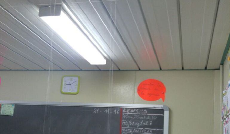 Imagen esta mañana de una de las aulas del 103 con el agua filtrándose por el techo