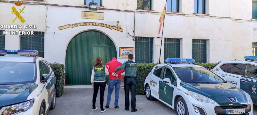 Dos agentes de la guardia civil sostienen al detenido