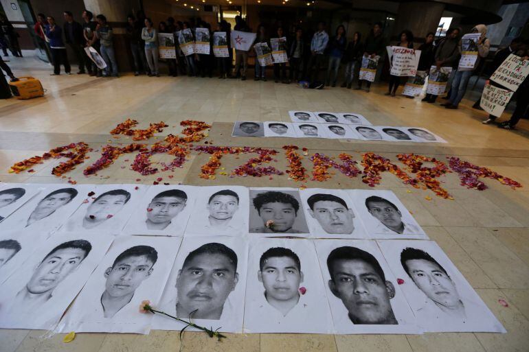 Portraits of some of the 43 missing students of the Ayotzinapa teachers training college Raul Isidro Burgos are placed on the floor as students take part in a protest in support of them outside the Mexican Embassy in Bogota November 7, 2014. The students 