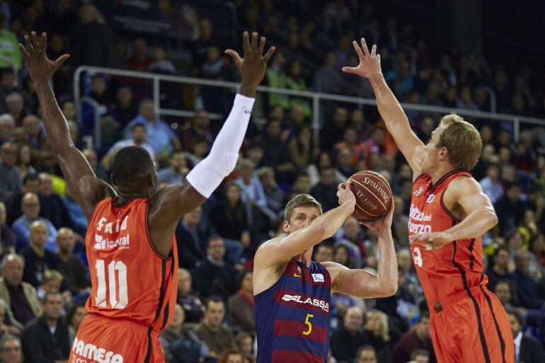 GRA221. BARCELONA, El ala pívot norteamericano del Barcelona Lassa Justin Doellman (c) con el balón ante los jugadores del Valencia Basket Romain Sato (i) y Luke Sikma (d) durante el partido de la decimocuarta jornada de Liga que disputan en Barcelona. EF