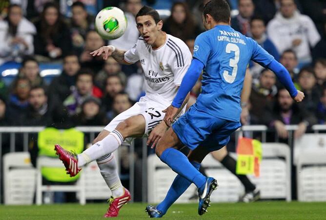 El argentino del Real Madrid Ángel Di María centra el balón junto al defensa José Peris, del Olímpic de Xátiva, durante el partido de vuelta de dieciseisavos de final de la Copa del Rey.