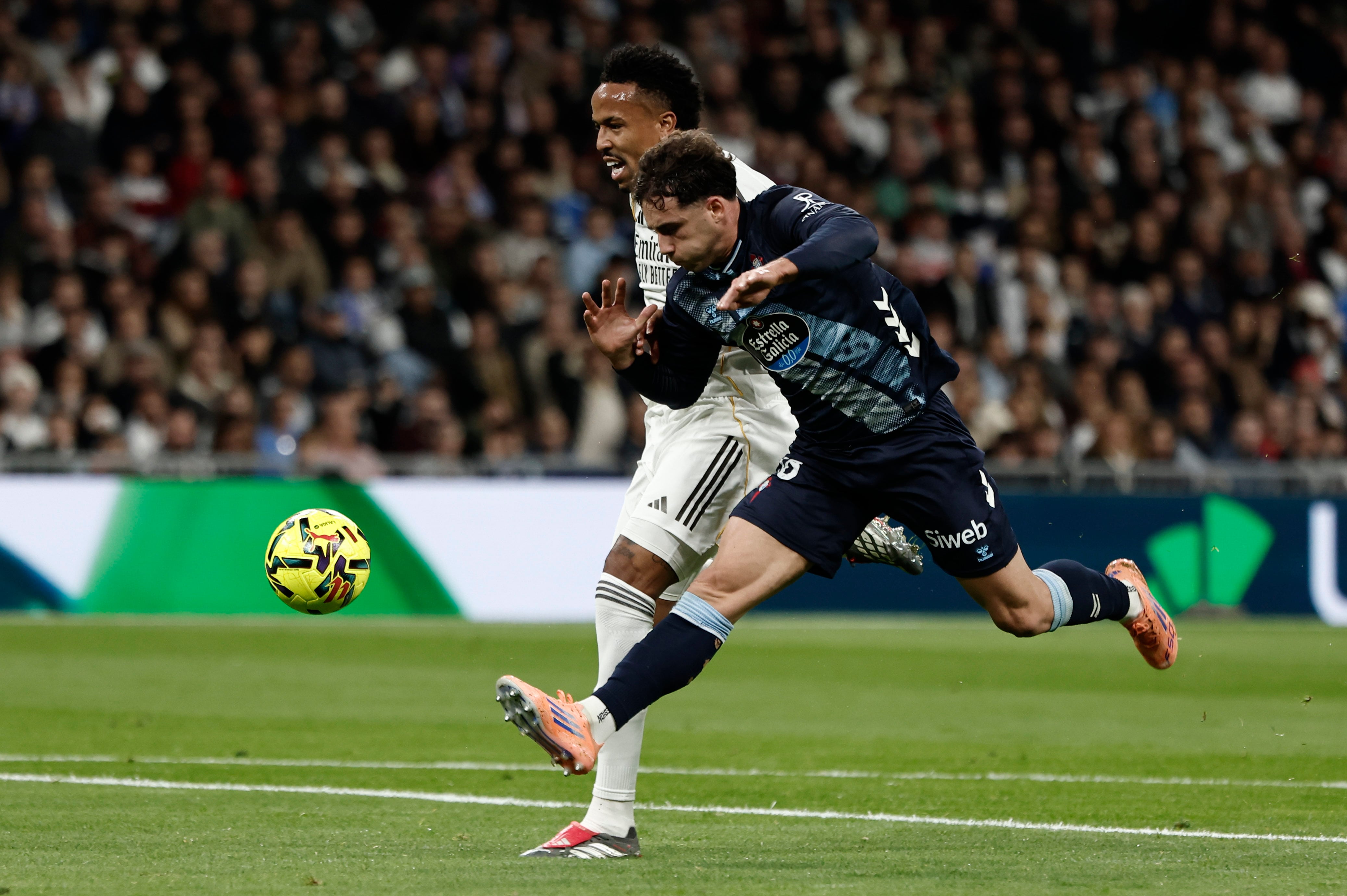 MADRID, 07/12/2025.- El defensa del Real Madrid Éder Militao (i) pelea un balón con Pablo Durán, del Celta, durante el partido de LaLiga de fútbol que Real Madrid y Celta de Vigo disputan este domingo en el estadio Santiago Bernabéu. EFE/Sergio Pérez