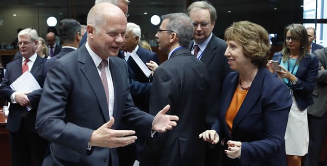 El ministro de Asuntos Exteriores británico, William Hague (izq), conversa con la jefa de la diplomacia europea, Catherine Ashton (dcha), antes de una reunión de urgencia de los ministros de Exteriores de la Unión Europea