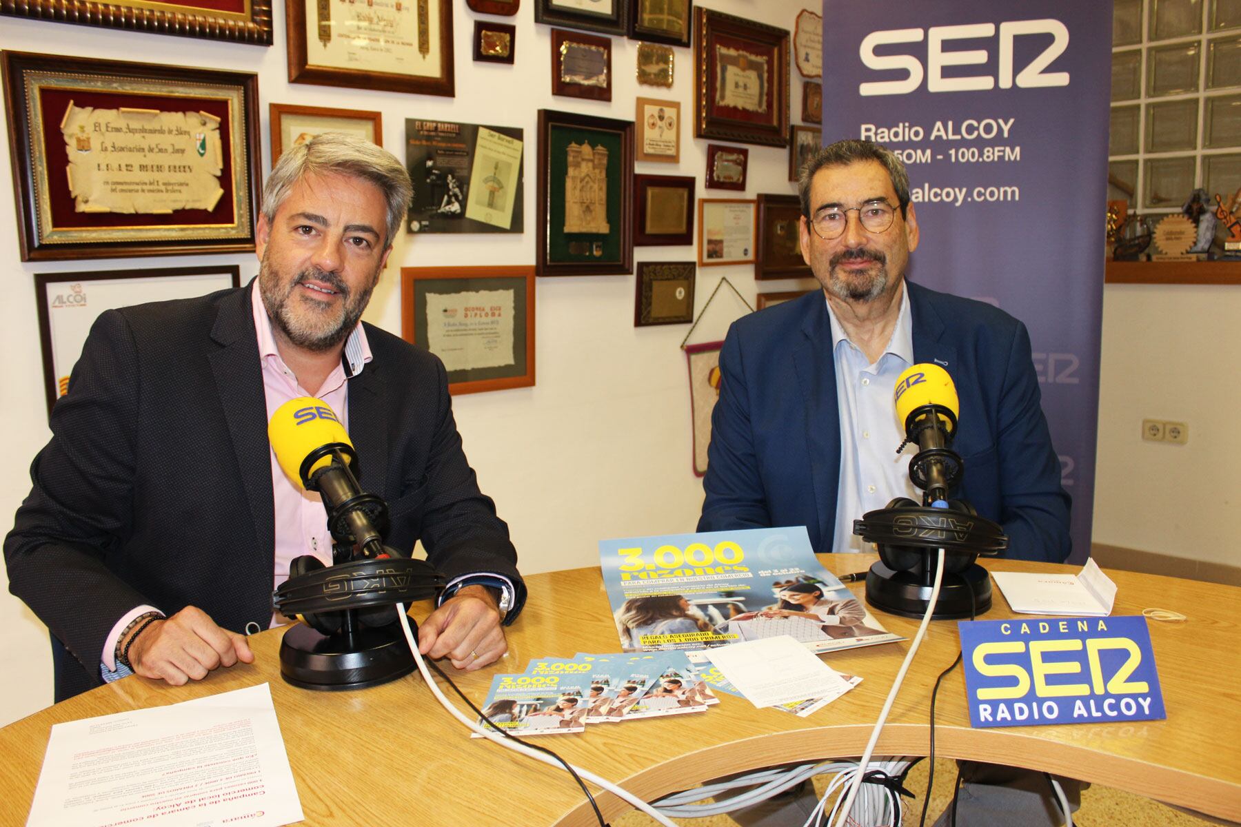 Pablo de Gracia y Paco Expósito, con carteles de la campaña, en el estudio central de Radio Alcoy