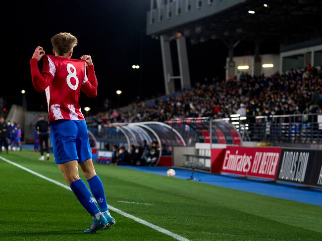 Pablo Barrios muestra la camiseta del Atlético durante el partido contra el Madrid