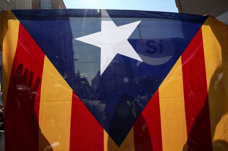 Un hombre sostiene una estelada frente a la oficina de Unipost 