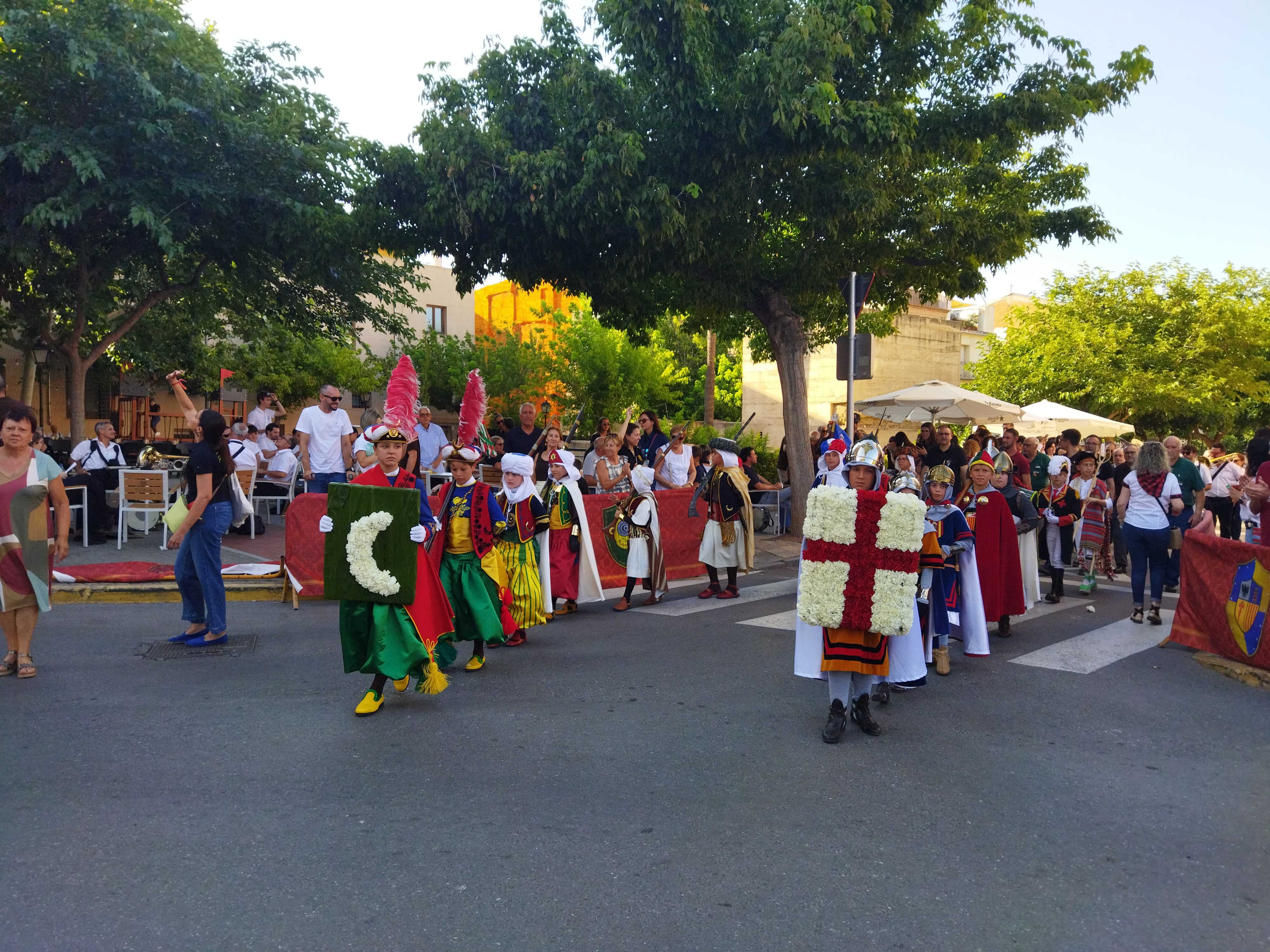 Los niños y las niñas entrando a la plaza Alcalde Reig con las flores para el patrón.