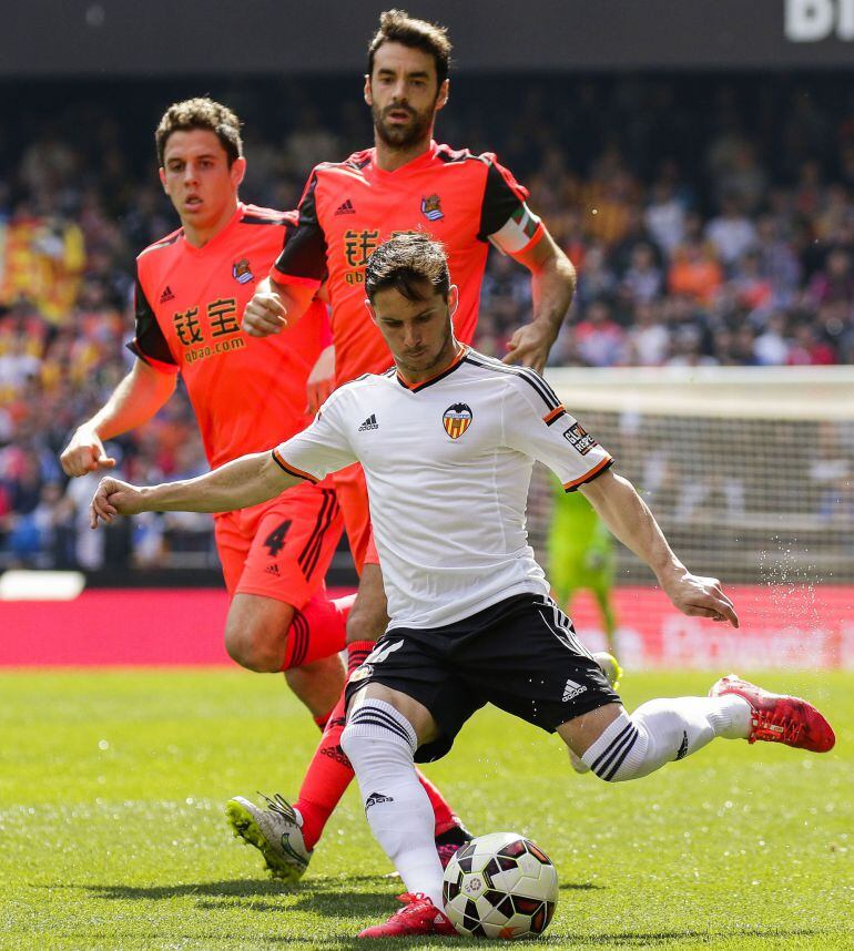 Valencia&#039;s Argentinian forward Pablo Piatti (R bottom) kicks the ball next to Real Sociedad&#039;s midfielder Xabi Prieto (R top) and Real Sociedad&#039;s midfielder Gorka Elustondo (L) during the Spanish league football match Valencia CF vs Real Sociedad de Futbol at the Mestalla stadium in Valencia on March 1, 2015.   AFP PHOTO/ JOSE JORDAN