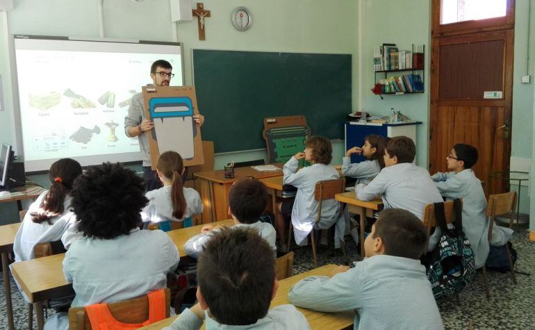 Un profesor enseña a sus alumnos como compostar.