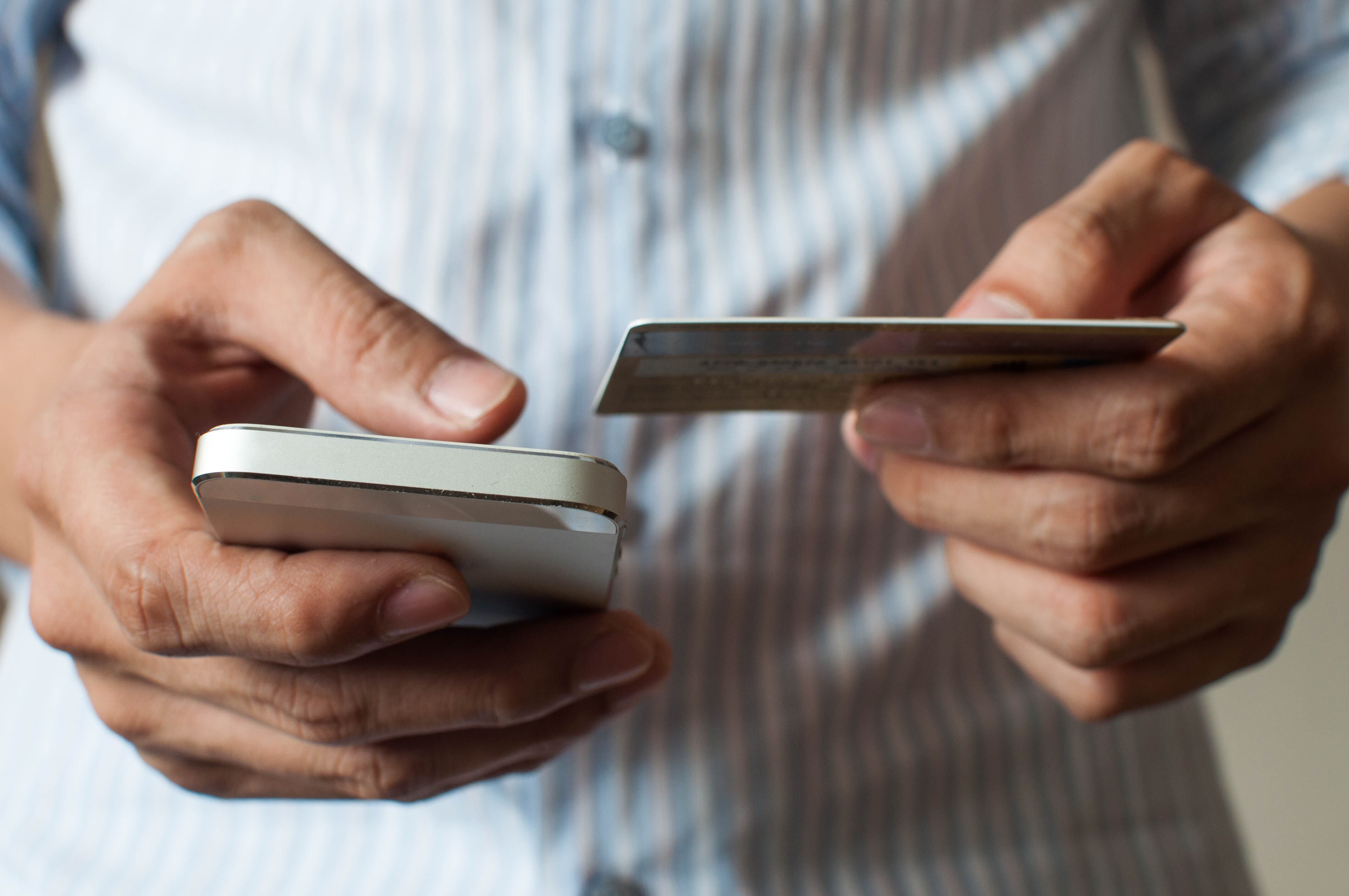 A businessman is buying online using his mobile phone and credit card