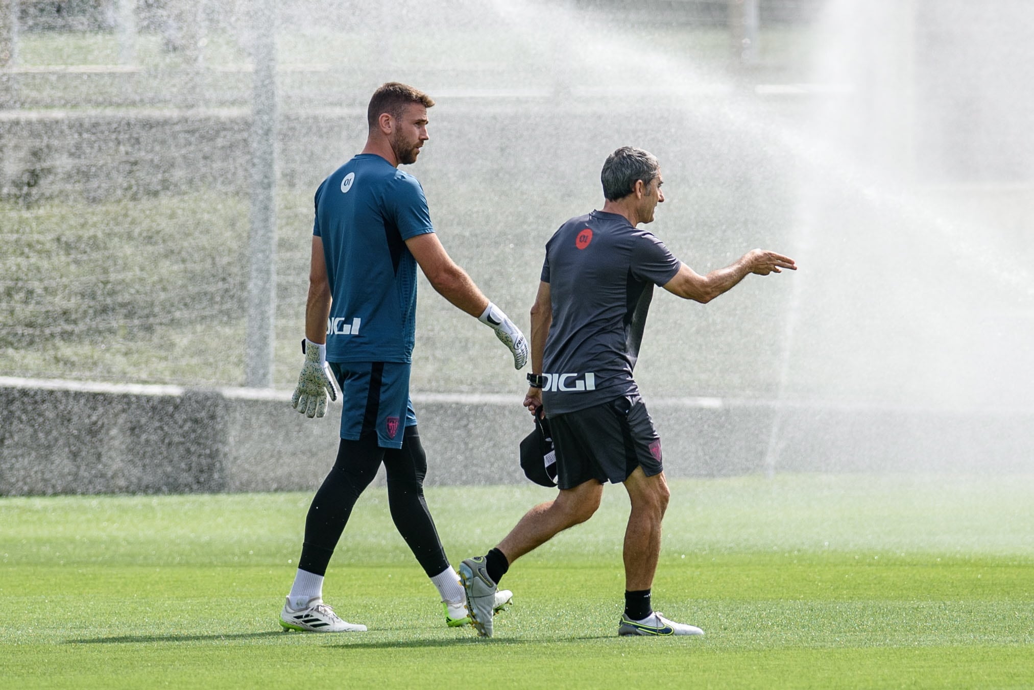 GRAFCAV2088. LEZAMA, 10/08/2023.-. El entrenador del Athletic de Bilbao, Ernesto Valverde (d), da indicaciones al portero Unai Simón (i) durante el entrenamiento que el club rojiblanco ha celebrado este jueves previo al debut liguero del sábado ante el Real Madrid en San Mamés. EFE/Javier Zorrilla
