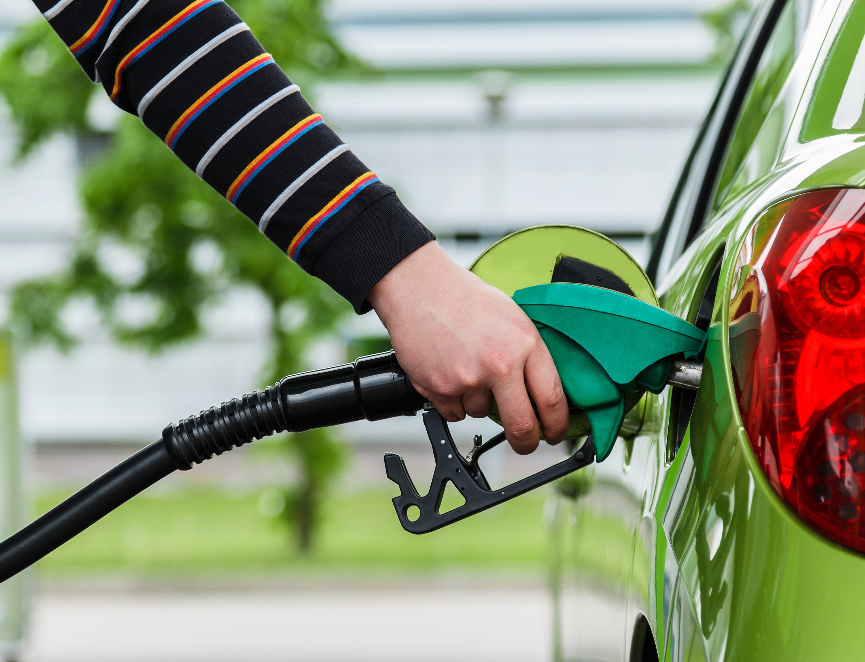 Una mujer reposta combustible en una gasolinera