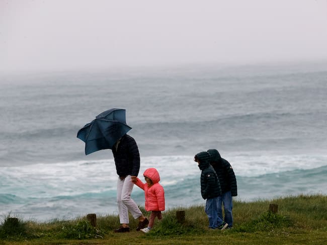 FERROL, 27/03/2024.-Una familia pasea por la costa de Ferrol este miércoles. Los días festivos de Semana Santa estarán dominados por la borrasca Nelson que va a dejar fuertes rachas de viento, nieve, mal estado de la mar y sobre todo lluvias en casi toda la península, más abundantes en el oeste y franja central peninsular y menos probables en el área mediterránea y Baleares.-EFE/ Kiko Delgado