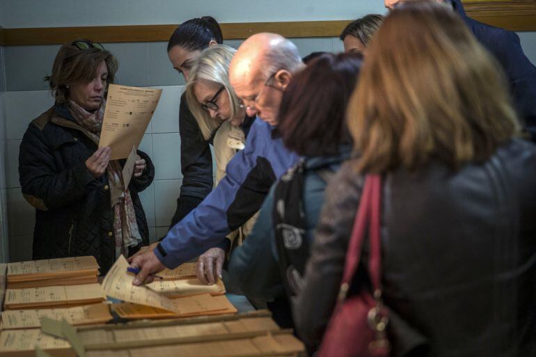 Los primeros votantes seleccionan sus papeletas antes de ejercer su derecho al voto