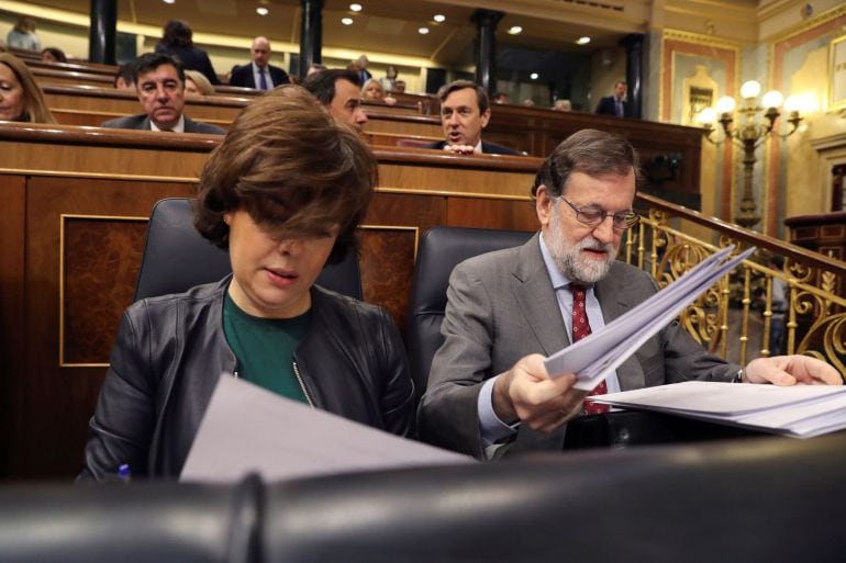 El presidente del Gobierno, Mariano Rajoy, y la vicepresidenta, Soraya Sáenz de Santamaría (i), al inicio de la sesión al Ejecutivo celebrada hoy en el Congreso