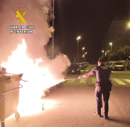 Un Guardia Civil apaga un contenedor ardiendo