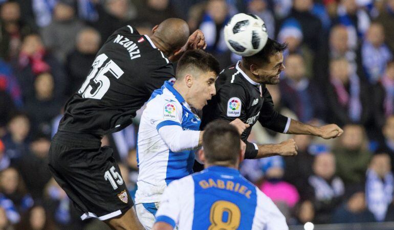 El defensa del Leganés Unai Bustinza (c) salta por el balón con el francés Steven Nzonzi (i) y el argentino Gabriel Mercado (d), ambos del SEvilla FC, en partido de ida de semifinales de la Copa del Rey en el estadio de Butarque.