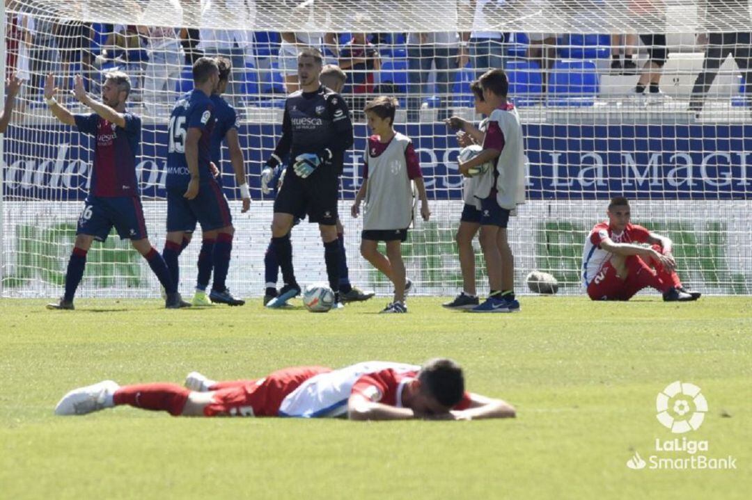 Contraste entre la rabia de los jugadores del Sporting al final del partido y la alegría de los oscenses