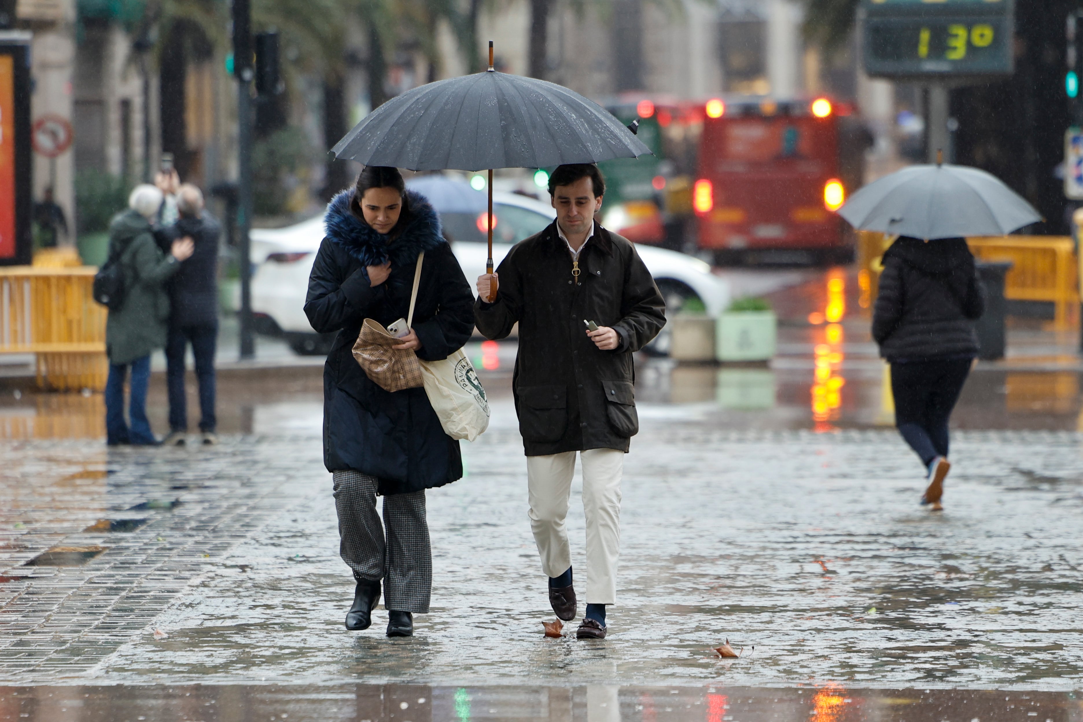 GRAFCVA6017. VALENCIA, 05/03/2025.- Varias personas se protegen con paraguas de la lluvia que puede acumular 100 litros por metro cuadrado en doce horas en las provincias de Valencia y Castellón durante este miércoles y mañana jueves, y en todo el episodio de precipitaciones que lleva activo desde el lunes se pueden alcanzar o superar los 400 litros acumulados, especialmente en el interior y prelitoral según la Agencia Estatal de Meteorología (Aemet). EFE/Biel Aliño
