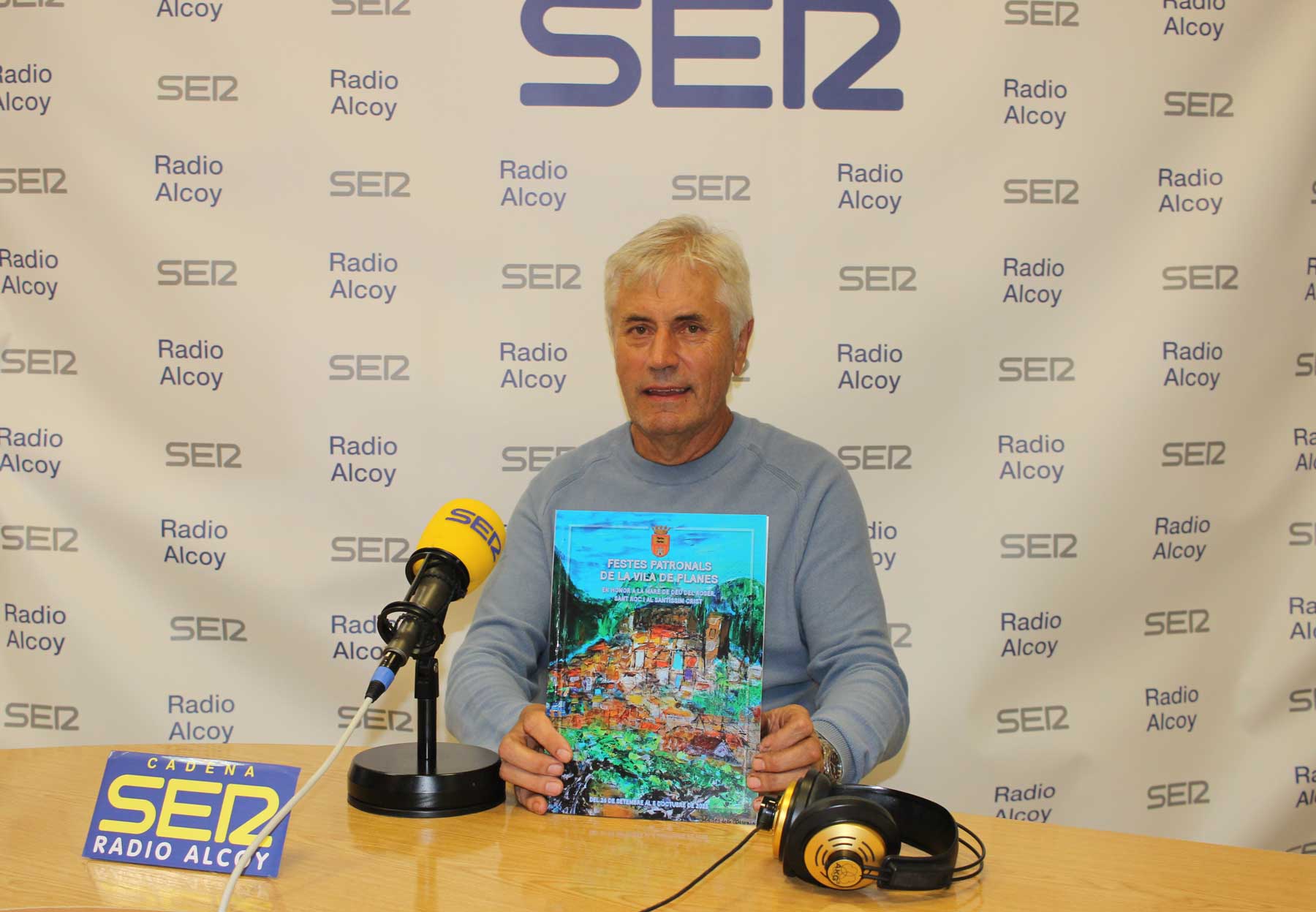 Agustí Cebrià, en l'estudi central de Radio Alcoy, amb un exemplar del programa de festes de Planes