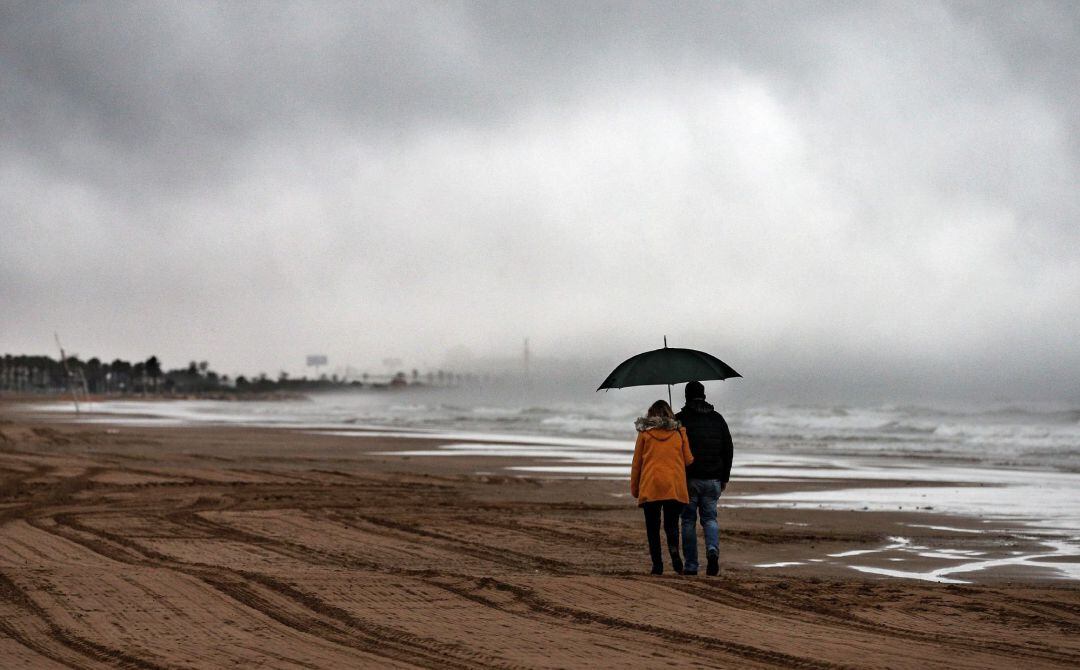 Una pareja pasea por la playa de la Malvarrosa de Valencia este Viernes Santo.