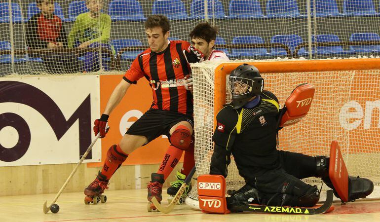 Joan Salvat condueix una pilota davant un jugador del Vic.