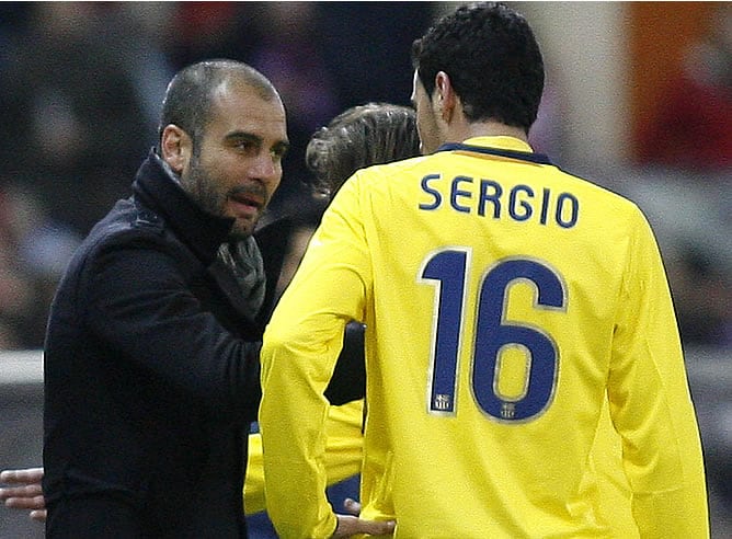 Busquets habla con Guardiola durante el partido ante el Atlético