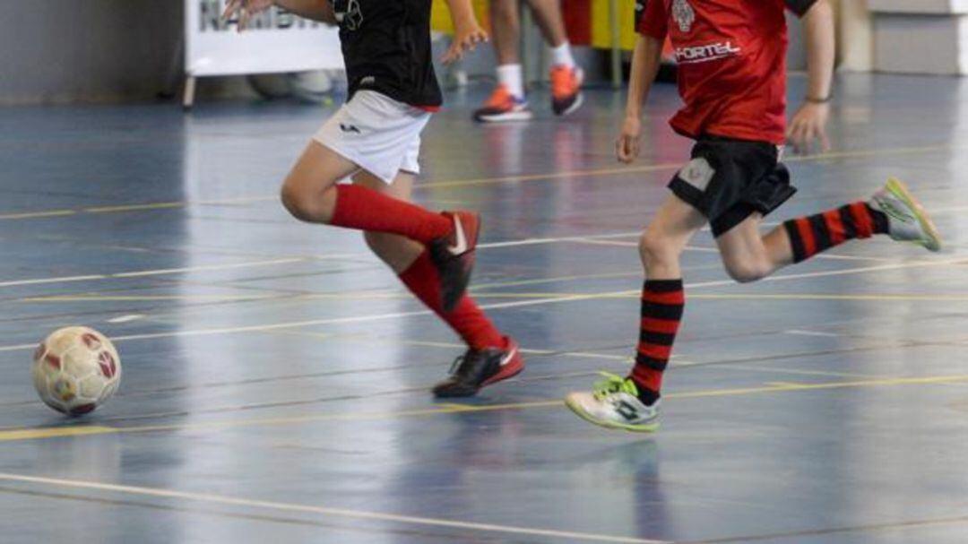 Dos niños juegan al fútbol sala