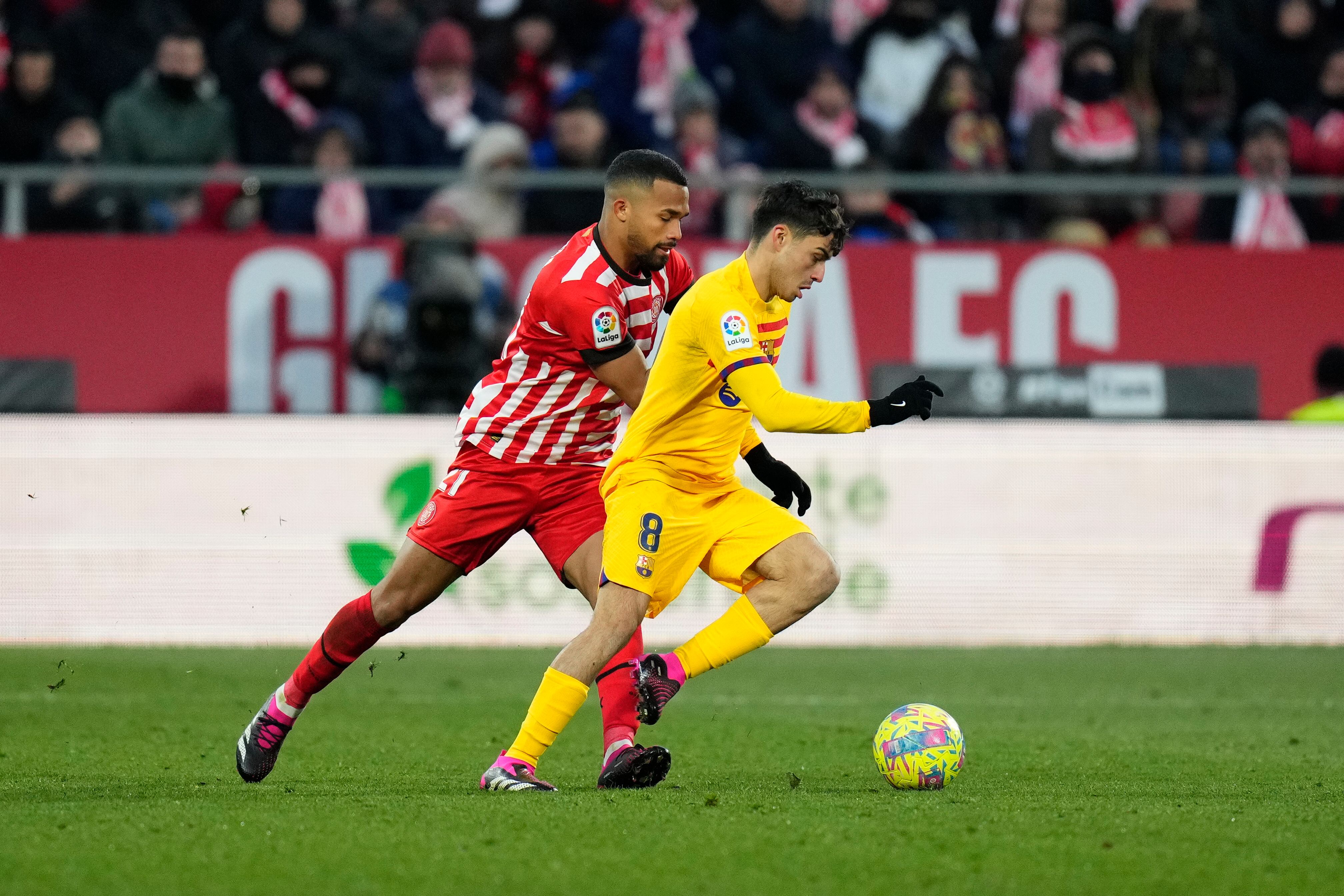 El delantero del FC Barcelona Pedri (d) y el delantero del Giroa Yangel Herrera, durante el partido de LaLiga entre el Girona CF y el FC Barcelona, este sábado en el Estadio Montilivi, en Girona. EFE/ Siu Wu