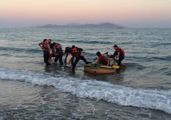 Un grupo de refugiados desembarca en la playa de la Isla de Kos