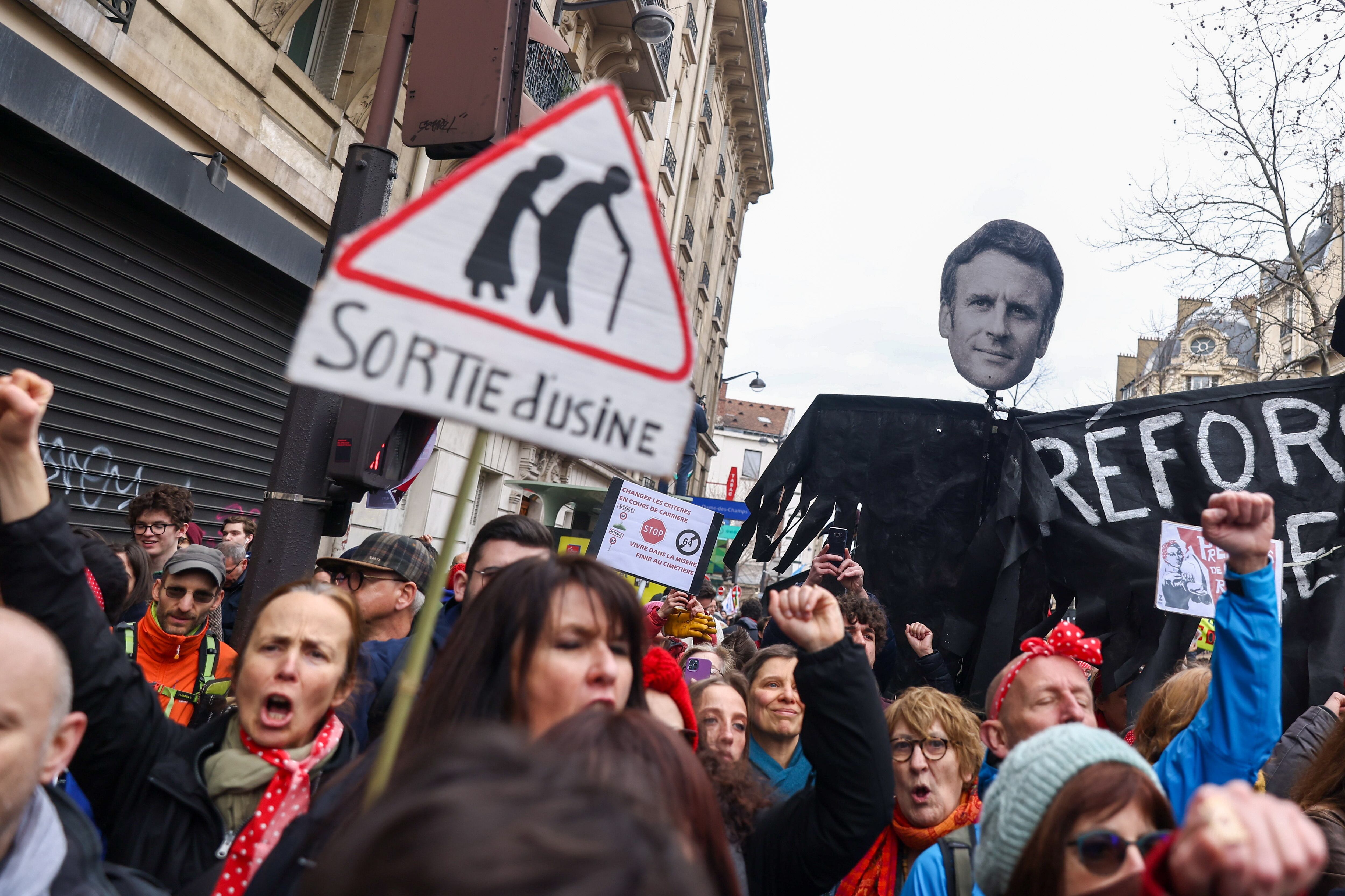 Los manifestantes sostienen una pancarta que muestra el rostro del presidente francés Macron, durante una protesta contra la reforma del sistema de pensiones en París