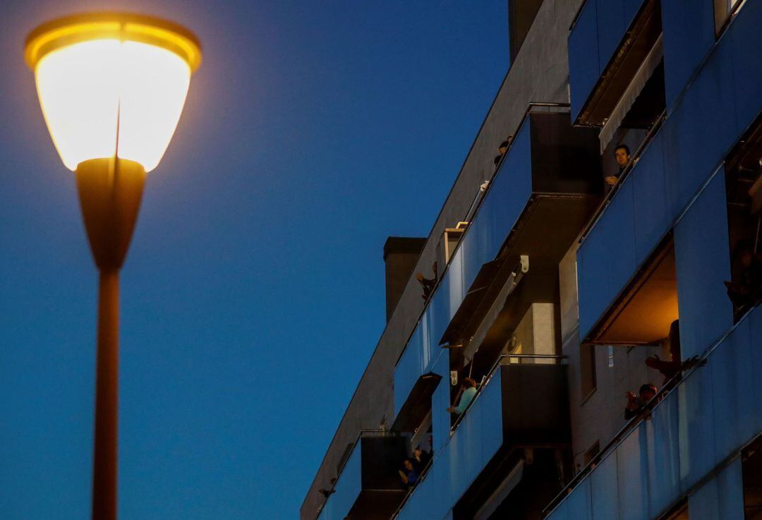 Varios vecinos aplauden desde los balcones de sus casas durante uno de los días de cuarentena.