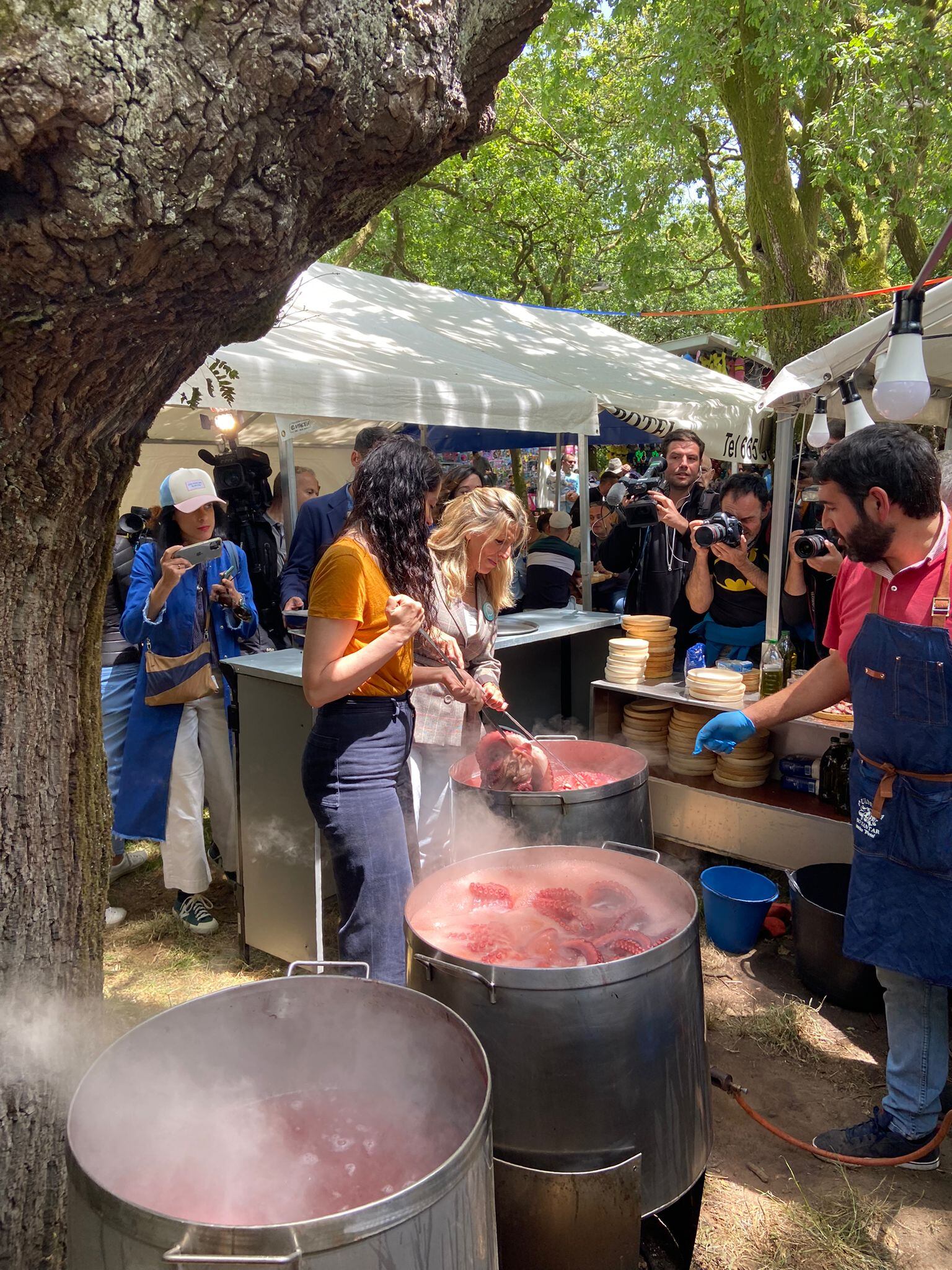 Yolanda Díaz y María Rozas cociendo el pulpo en la Alameda, en las fiestas de la Ascensión, en Santiago de Compostela