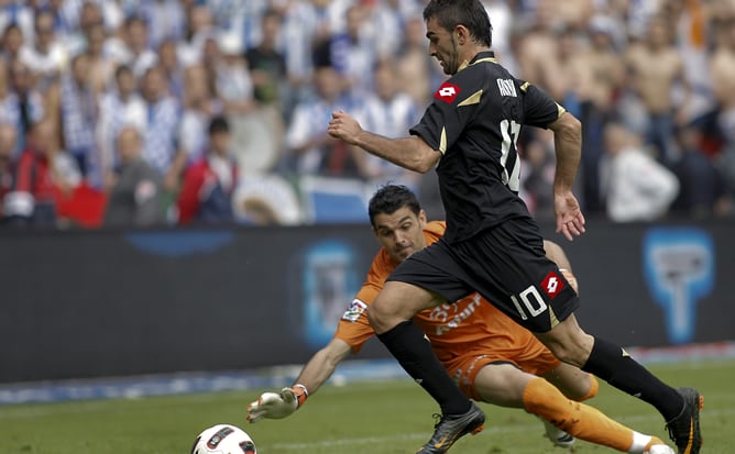 El portero del Sporting de Gijón, Juan Pablo (i) y el delantero del Deportivo, Adrián López (d) en la jugada del segundo gol del Deportivo, durante el partido, correspondiente a la trigésima quinta jornada del Campeonato Nacional de Liga de Primera Divisi