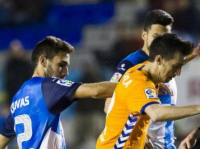 Lanza luchando por un balón rodeado de rivales.