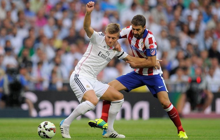 El capitán del Atlético disputa un balón con Kroos.