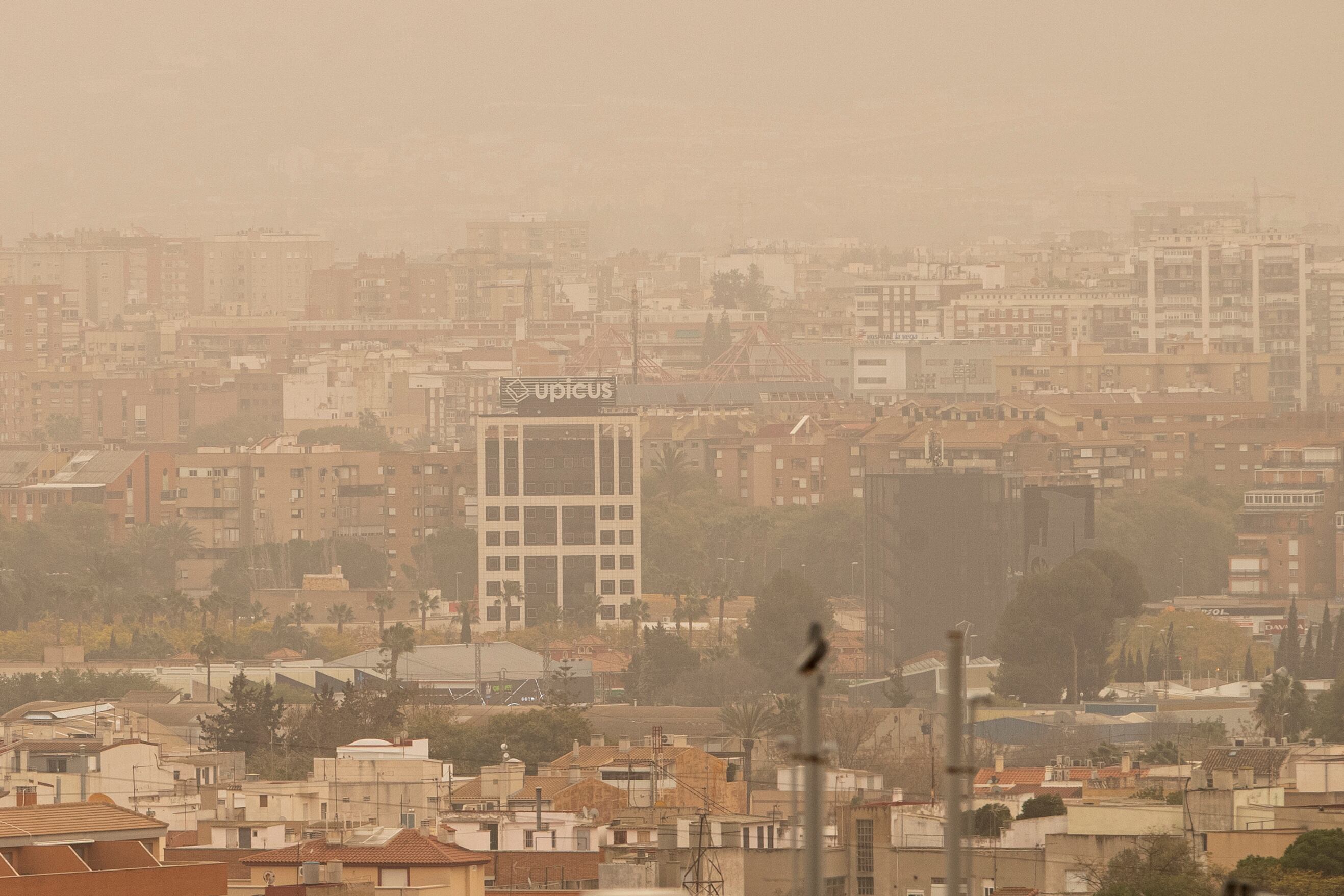 MURCIA, 15/03/2022.- Vista de la ciudad de Murcia cubierta con una neblina de color rojo por el alto número de partículas y polvo en suspensión este martes. La llegada de una lengua de polvo en suspensión procedente del desierto del Sáhara, impulsada por los vientos de la borrasca Celia, ha elevado a la categoría de &quot;extremadamente desfavorable&quot; la calidad del aire en amplias zonas del país, por los altos niveles de concentración de partículas PM10, afectando seriamente a la salud. EFE/Marcial Guillén
