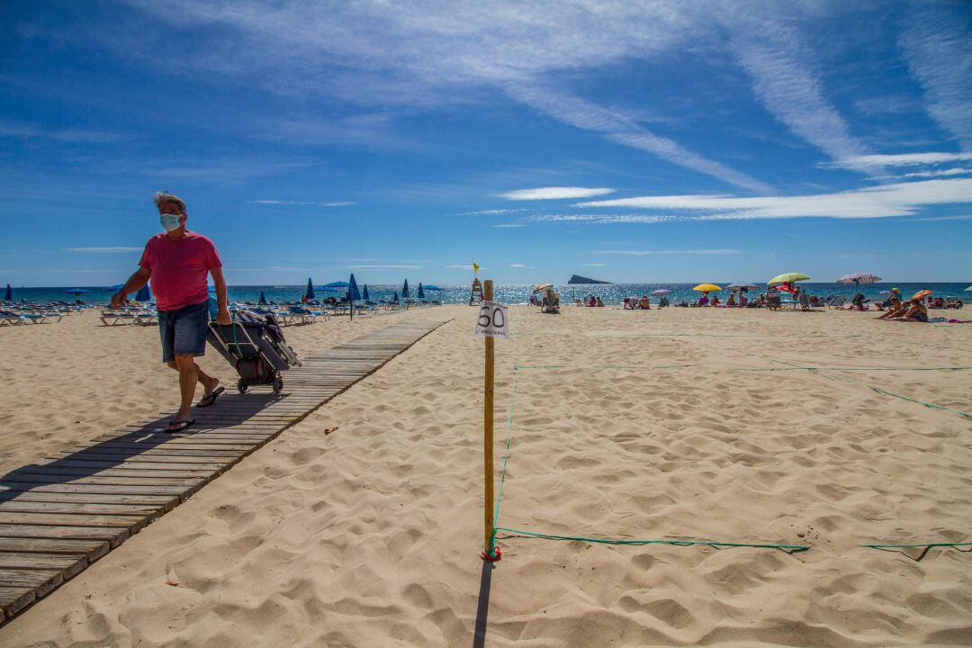 Un hombre camina por la pasarela de la Playa de Levante de Benidorm.