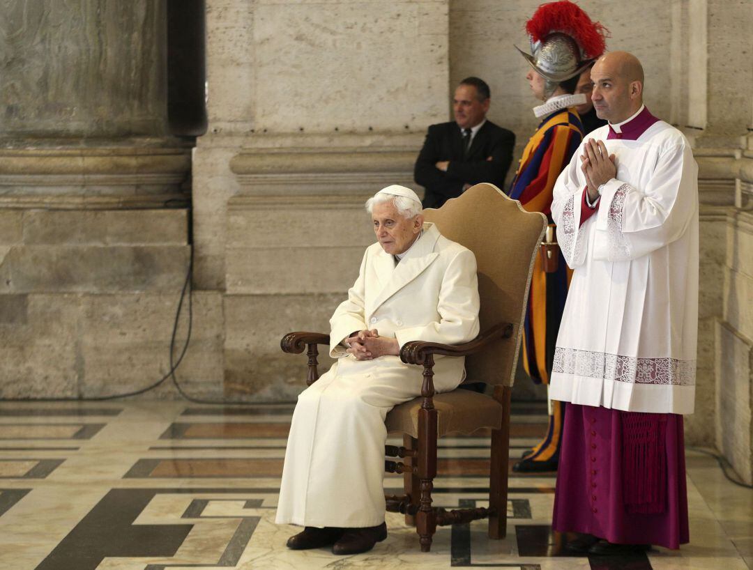 Benedicto XVI se sienta cerca de la Puerta Santa cuando el Papa Francisco dirige una misa para conmemorar la inauguración del Año Santo Católico.