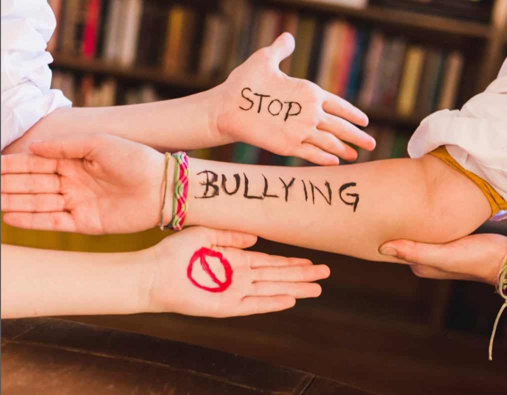 Imagen de archivo de varias manos con la palabra &#039;stop bullying&#039; pintada 