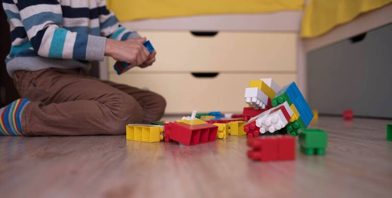 Un niño juega con piezas de construcción en una guardería