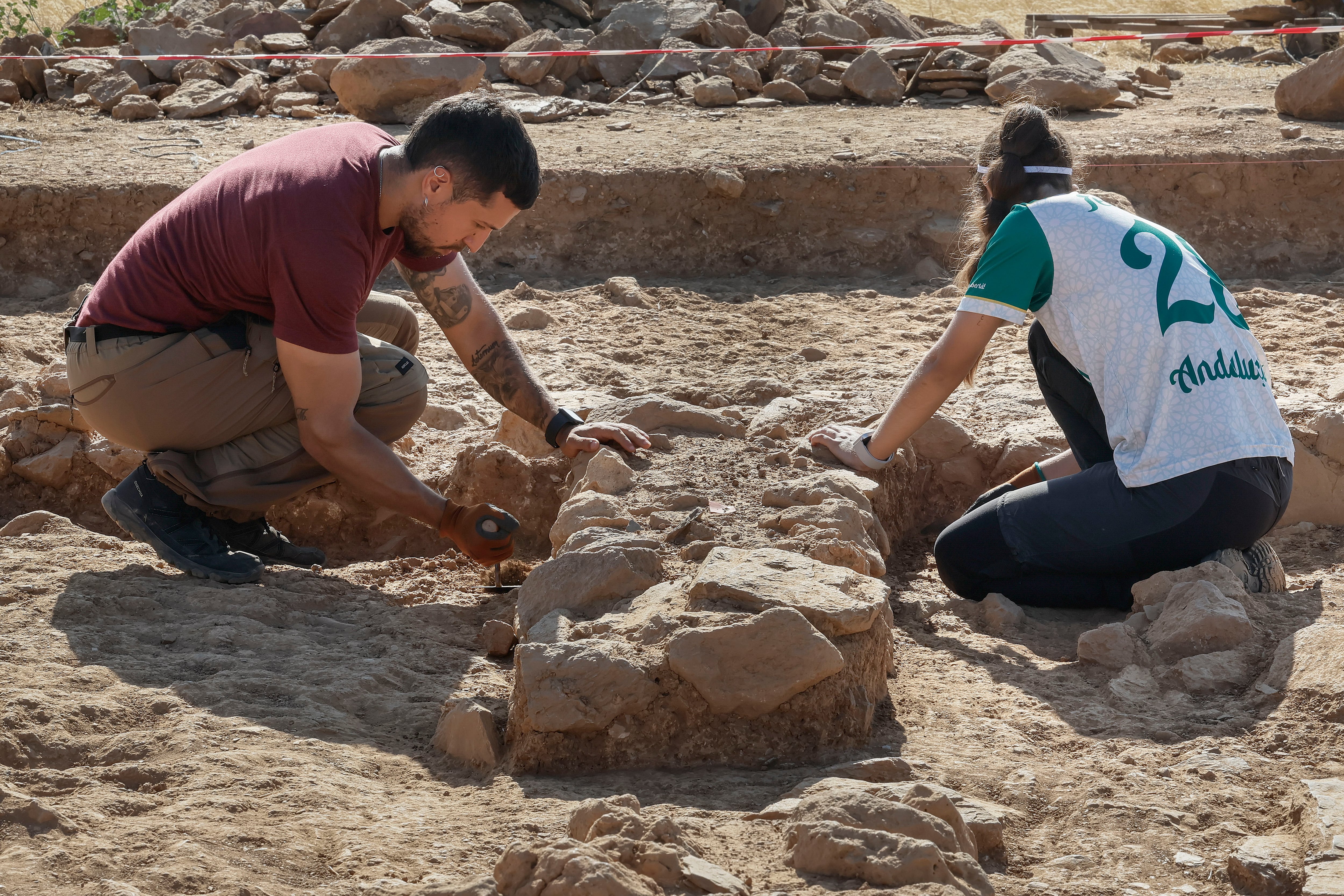 Dos jóvenes trabajan en las excavaciones en el yacimiento tartesio de Tejada la Vieja, en Escacena, Huelva.