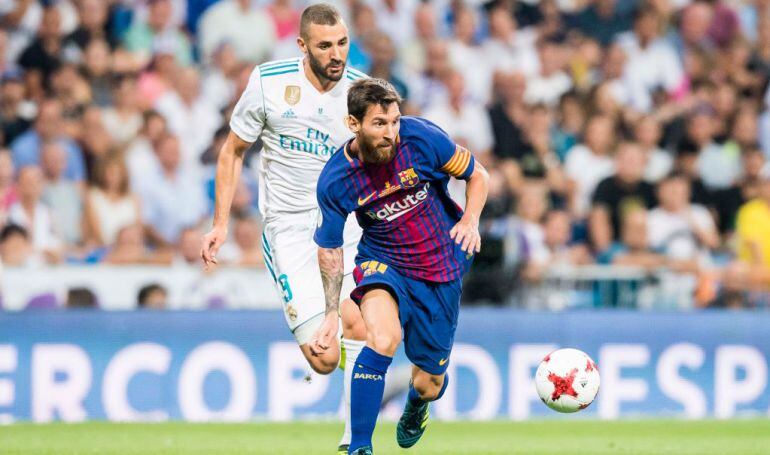 Messi controla un balón bajo la atenta mirada de Benzema