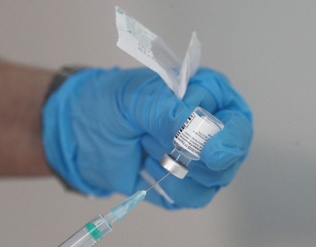 Un enfermero prepara una vacuna antes de inyectársela a un trabajador sanitario