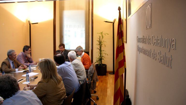 Imatge de la reunió de la mesa de seguiment dels casos d'enterovirus a Catalunya, presidida pel conseller Antoni Comín, amb un cartell del Departament de Salut a la paret i una senyera davant