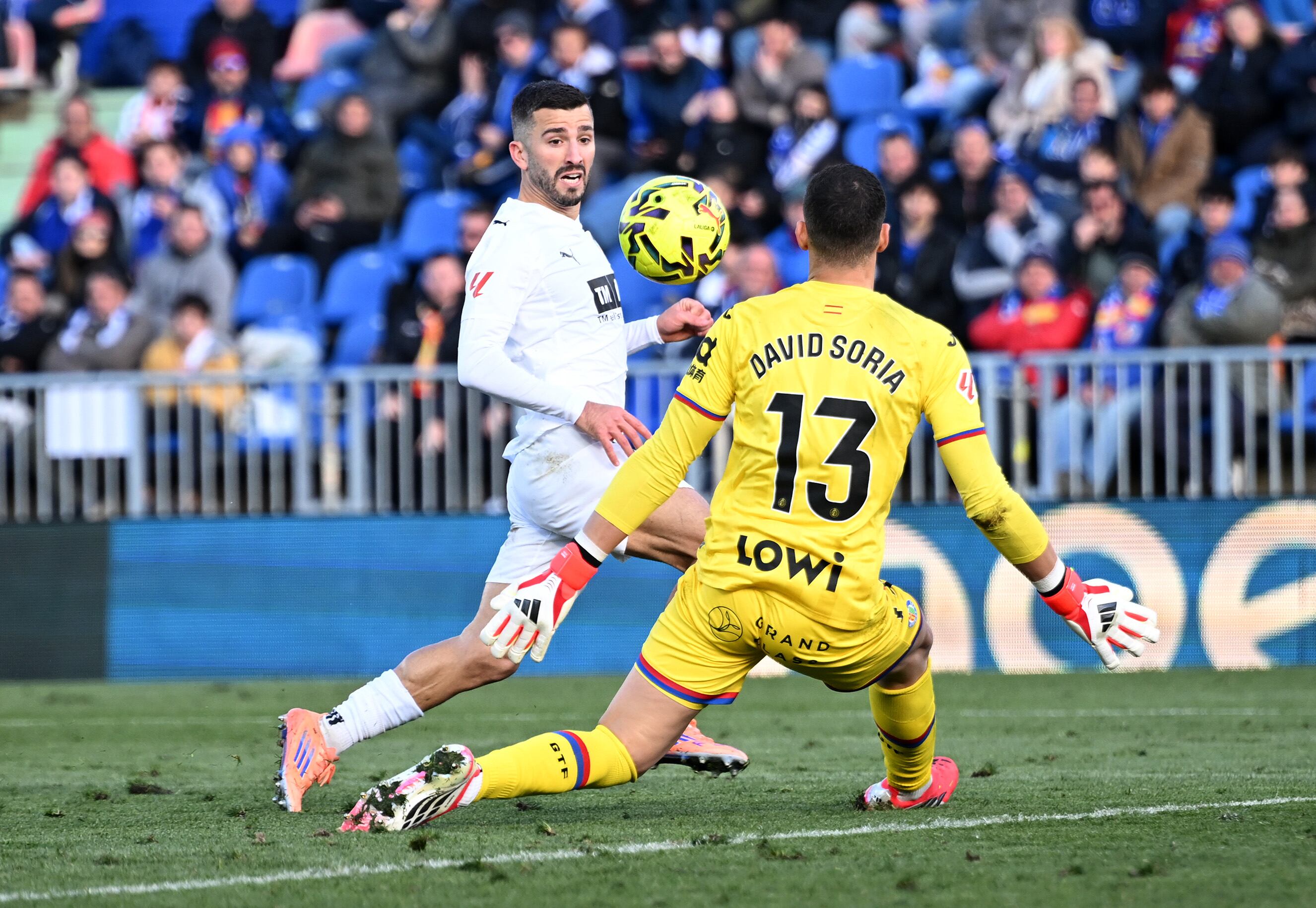 Gayà picando el balón por encima de David Soria
